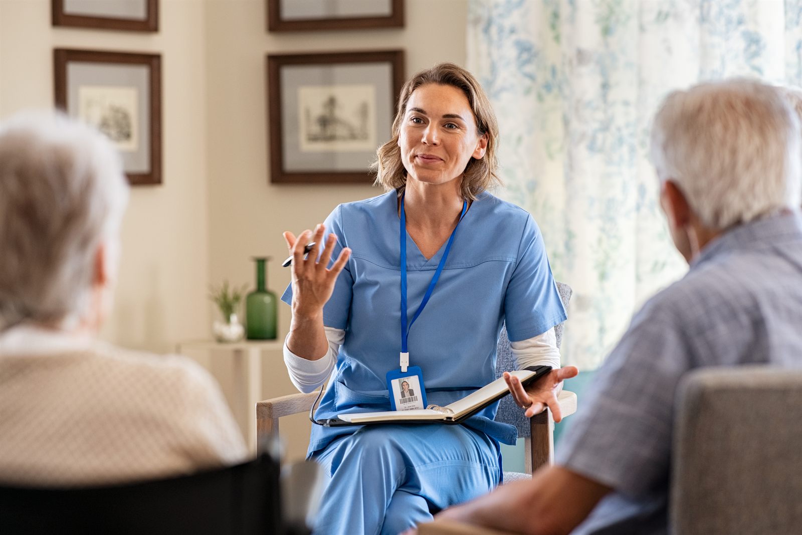 A nurse in conversation with residents at a care facility